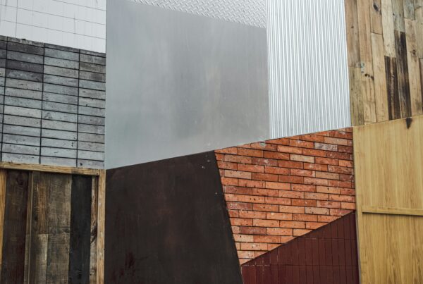 Sammensætning af byggematerialer i træ, tegl, metal og fliser, der illustrerer workshop om digitalt produktpas for byggevarer og data i byggeriet